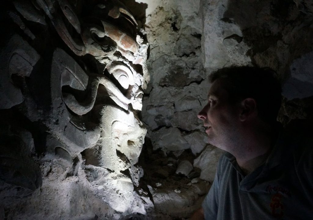 Garrison comes face to face with a mask inside one of the site’s pyramids. (USC Photo/Robert Perkins)