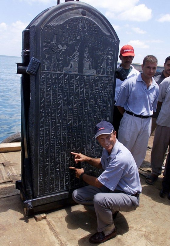 French Marine archaeologist Frank Goddio explains text on the stele of Heracleion on a barge in an Alexandria naval base June 7, 2001.