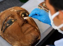 An archaeologist works on an artifact, around 2,500 years old, from the newly discovered burial site near Egypt's Saqqara necropolis, during a presentation in Giza, Egypt November 14, 2020. REUTERS